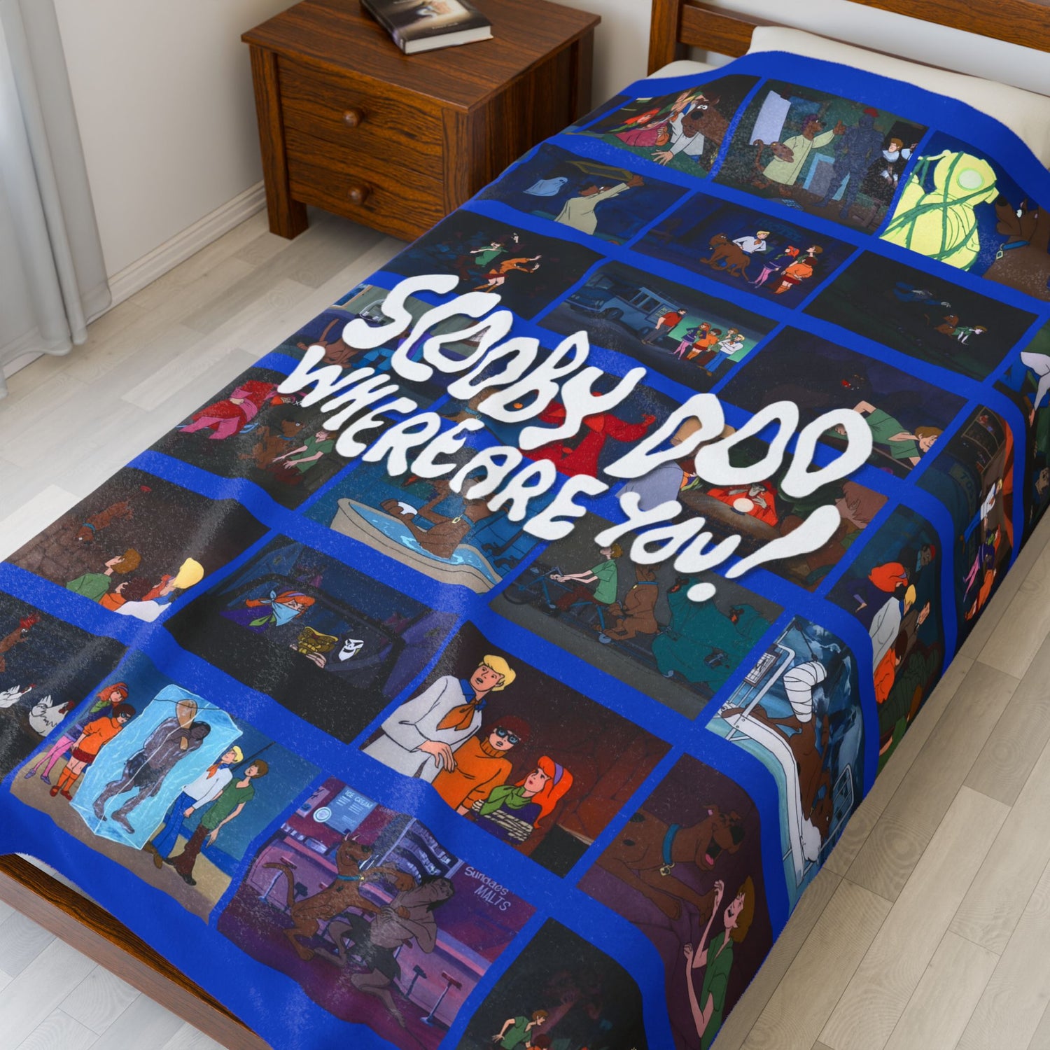 Bedspread with cartoon characters and text 'Scooby Doo, Where Are You?' on a bed in a room.
