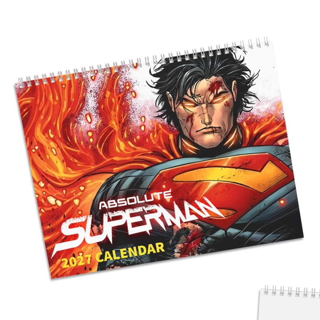 Two views of a spiral-bound 2027 Absolute Superman calendar on a white background: the front cover shows Superman with fiery red and orange artwork, and the blank back page has a small matching Superman portrait sticker in the lower left corner.
